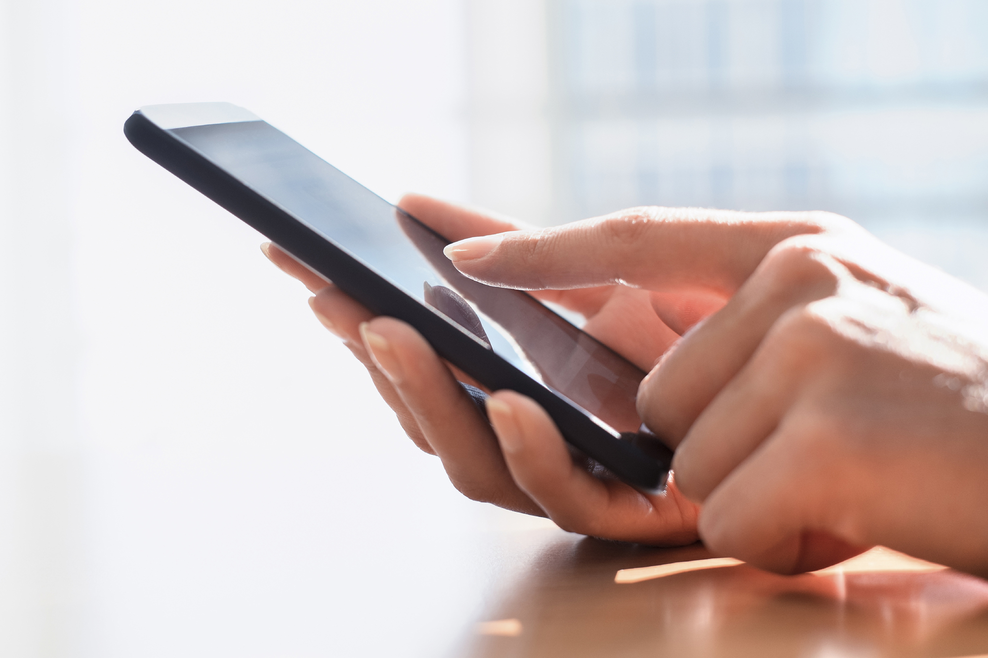 Close up of hands woman using her cell phone.